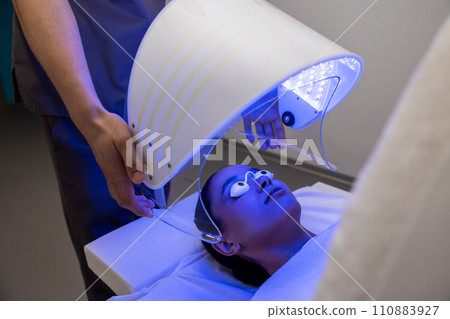Medical specialist working with a patient during the session of phototherapy Medical specialist working with a patient during the session of phototherapy 110883927