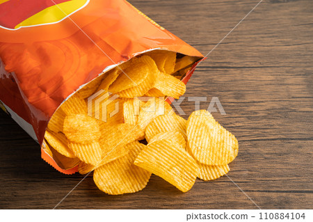 Potato chips, delicious BBQ seasoning spicy for crips, thin slice deep fried snack fast food in open bag. Potato chips, delicious BBQ seasoning spicy for crips, thin slice deep fried snack fast food in open bag. 110884104