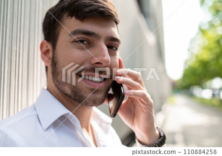 Young elegant man with a phone in hands Young elegant man with a phone in hands 110884258