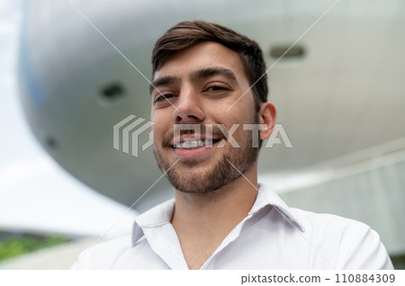 Young dark-haired man in white shirt smiling and feeling joyful 110884309