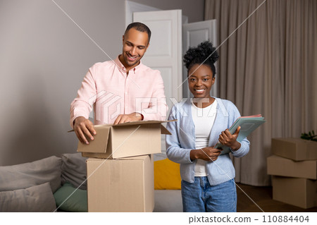 Man and woman house ownerships holding cardboard box moving to new apartment Man and woman house ownerships holding cardboard box moving to new apartment 110884404