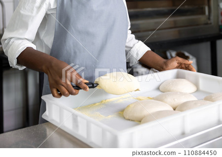 African american woman in pizzeria preparing for baking pizza African american woman in pizzeria preparing for baking pizza 110884450