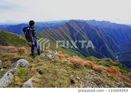 Climber looking at the southern part of the Hidaka Mountains from the summit of Pyramid Peak Climber looking at the southern part of the Hidaka Mountains from the summit of Pyramid Peak 110884849