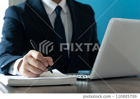 商人一邊看電腦一邊做筆記 110885789