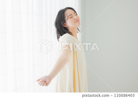 A young woman basking in the morning sunlight A young woman basking in the morning sunlight 110886403