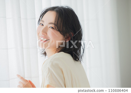 A young woman basking in the morning sunlight 110886404