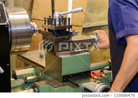 The machine operator working with lathe machine. The machine operator working with lathe machine. 110886479