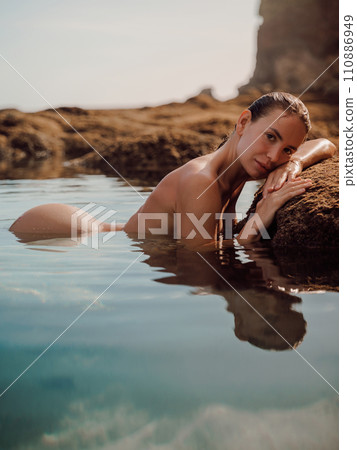 Young woman with wet body relaxing in sea. Beauty lady looking at camera in water 110886949