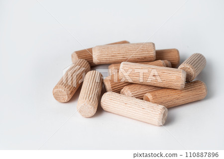 Pile of wooden dowels on the white background. 110887896