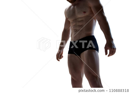Male athlete model with naked torso and packs of abs posing against white background. Man looks healthy and sporty. 110888318