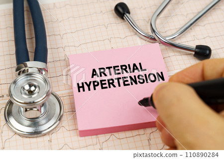 On the cardiograms there is a stethoscope and a sticker with the inscription - arterial hypertension On the cardiograms there is a stethoscope and a sticker with the inscription - arterial hypertension 110890284