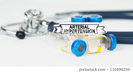 On the table there is a stethoscope, injections and a sign with the inscription - arterial hypertension 110890294