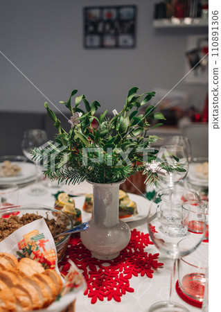 Christmas Eve's red borscht soup with mushroom filled ravioli and beet chips and sauerkraut with mushrooms on festive table. Polish Wigilia.  110891306