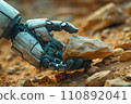 hand of a humanoid robot picks up a mineral sample from the surface of the planet 110892041