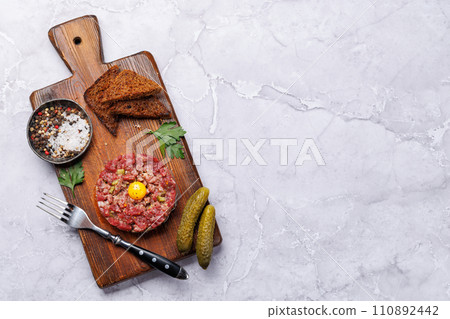 Savory beef tartare and brown bread toasts 110892442