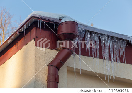 Big icicles on the roof of a townhouse 110893088