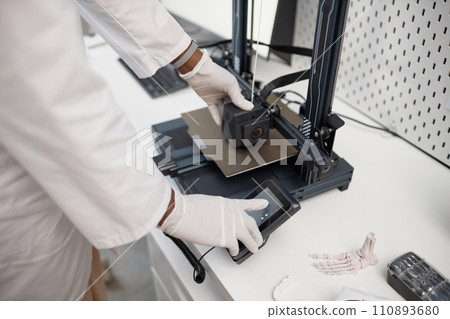 Top down view of unrecognizable technician gloved hands adjusting 3D printer settings with touchscreen interface in laboratory Top down view of unrecognizable technician gloved hands adjusting 3D printer settings with touchscreen interface in laboratory 110893680