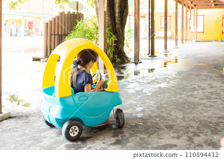 girl riding a toy car girl riding a toy car 110894412