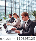 Businesspeople working on a laptops in an office with white walls, wide windows, dressed according to the business dress code and focused on work 110895125
