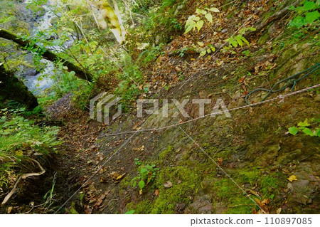 A rocky area with a rope on the old Mt. Ashibetsu trail 110897085