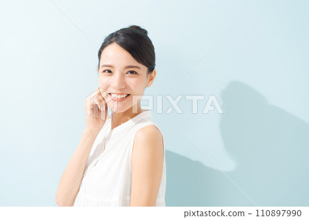 A woman in her 20s wearing a sleeveless blouse A woman in her 20s wearing a sleeveless blouse 110897990