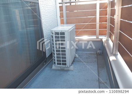 Air conditioner outdoor unit on balcony 110898294