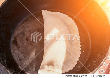 woman's hands making qutab or chebureki with a rolling pin and minced meat onion in dough for culinary concepts related to Azerbaijani, Tatar and Greek cuisine, as well as empanadas in Latin America. woman's hands making qutab or chebureki with a rolling pin and minced meat onion in dough for culinary concepts related to Azerbaijani, Tatar and Greek cuisine, as well as empanadas in Latin America. 110898949