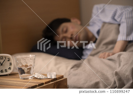 Sleeping pills - Insomnia - A man who takes medicine to sleep 110899247