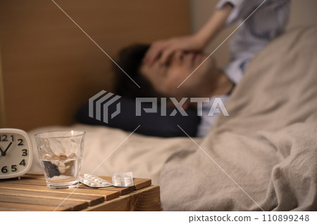 Sleeping pills - Insomnia - A man who takes medicine to sleep 110899248