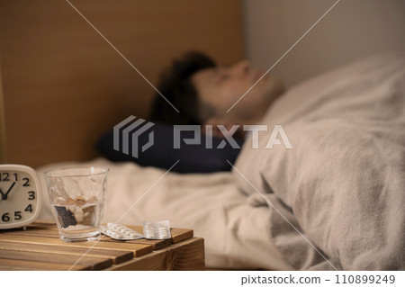 安眠藥 - 失眠 - 一個男人吃藥入睡 110899249