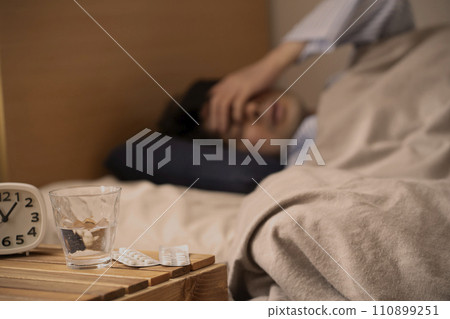 Sleeping pills - Insomnia - A man who takes medicine to sleep 110899251