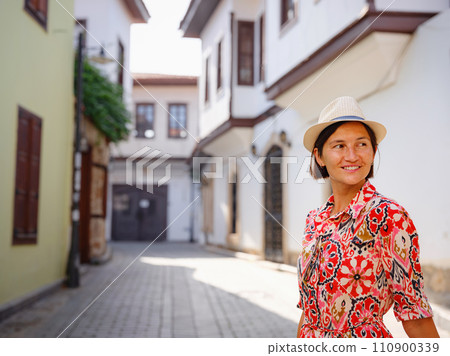 female summer travel to Antalya, Turkey. young asian woman in red dress walk through old town Kalechi , female tourist traveler discover interesting places and popular tourist attraction 110900339