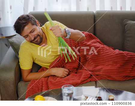 Sick man at home. Health care concept. choosing between evidence-based medicine and traditional medicine. pharmacological tablets against lemon, ginger and onion 110900836