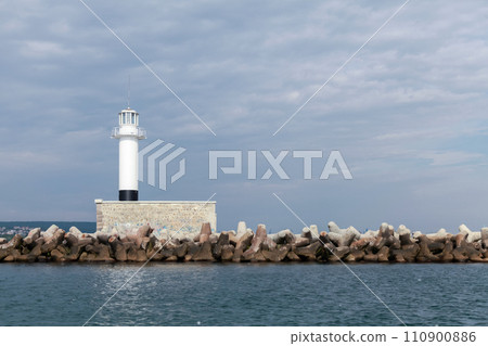 Breakwater with white lighthouse tower Breakwater with white lighthouse tower 110900886