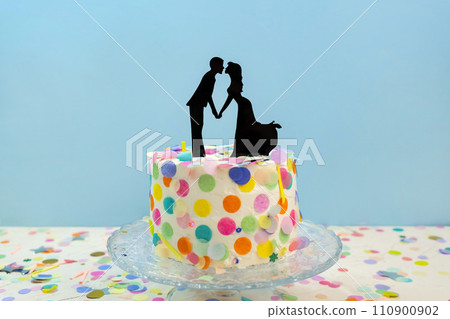 Bride and groom kissing wedding cake toppers on wedding cake 110900902