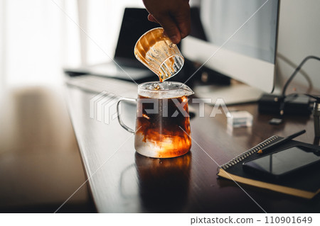 Iced coffee in a glass mug on the work desk Iced coffee in a glass mug on the work desk 110901649