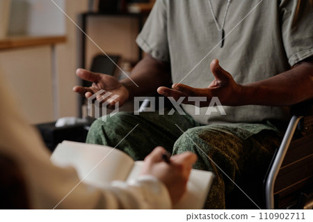 Black war veteran emotionally speaking during private therapy session, psychologist taking notes Black war veteran emotionally speaking during private therapy session, psychologist taking notes 110902711