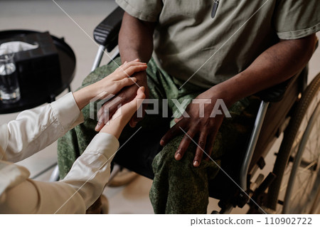 Caucasian therapist holding hand of her traumatized black patient providing moral support Caucasian therapist holding hand of her traumatized black patient providing moral support 110902722