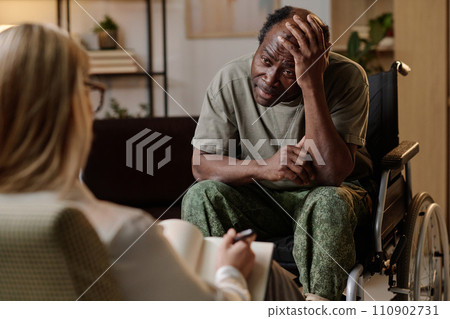 African american war veteran in wheelchair having emotional conversation with his female therapist 110902731