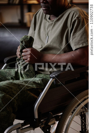 Frustrated senior african american soldier with PTSD in wheelchair holding his headwear Frustrated senior african american soldier with PTSD in wheelchair holding his headwear 110902738
