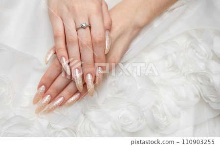 Hand of a young woman with white pearl manicure Hand of a young woman with white pearl manicure 110903255