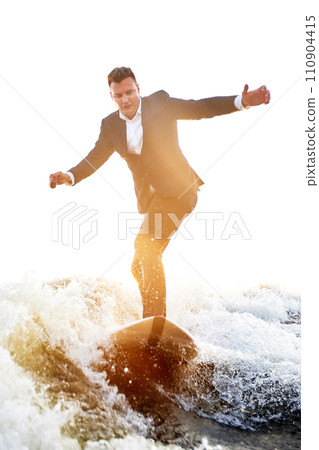Young man surfer in classic suit rides on the wave. Happy clerk escaped from stuffy office to take up active sport. Best summer leisure after routine work. Film grain effect. Sun flare. 110904415