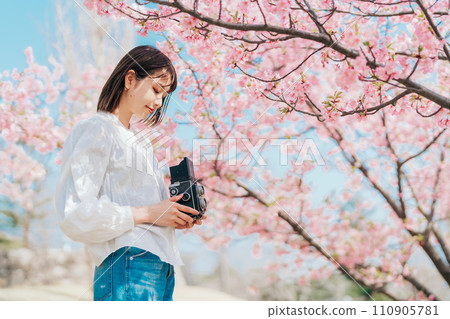 用底片相機拍攝櫻花的年輕女子 用底片相機拍攝櫻花的年輕女子 110905781
