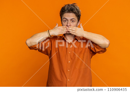 Frightened young man closing mouth with hands refusing to tell terrible secret unbelievable truth Frightened young man closing mouth with hands refusing to tell terrible secret unbelievable truth 110906435