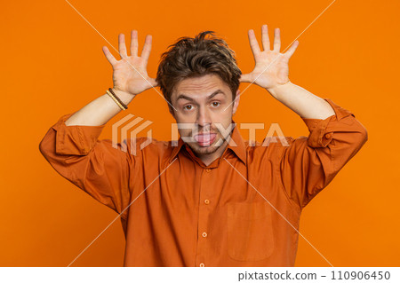 Funny bully Caucasian young man showing tongue making silly faces, fooling around, joking, teasing 110906450