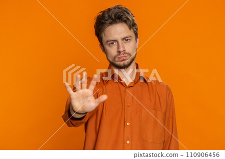 Young man says no hold palm hands in stop gesture warning of finish prohibited access Young man says no hold palm hands in stop gesture warning of finish prohibited access 110906456