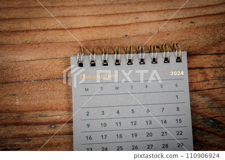 DECEMBER 2024. Green cardboard calendar on a wooden texture background 110906924