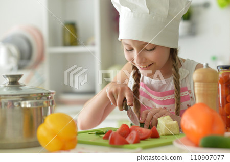 Cute girl preparing delicious fresh salad in kitchen at home Cute girl preparing delicious fresh salad in kitchen at home 110907077