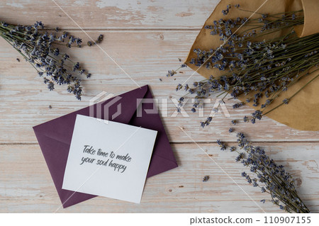 TAKE TIME TO MAKE YOUR SOUL HAPPY text on supportive message paper note reminder from green envelope. Flat lay composition dry lavender flowers. Concept of inner happiness, slowing-down digital detox 110907155
