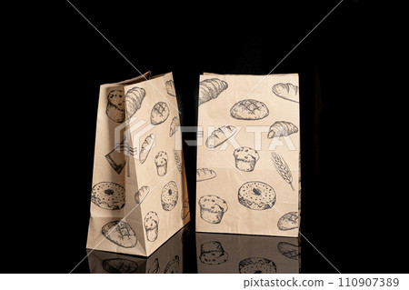 Recyclable craft paper bag for purchases, gifts and takeaway food mock up on black background. Environmentally friendly than single-use plastic bags 110907389